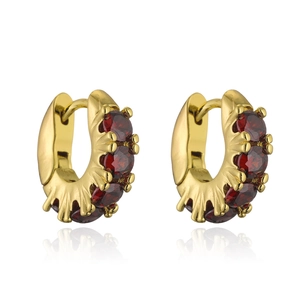 Macro detail of 18K gold hoop earrings with dark red cubic zirconia in claw settings