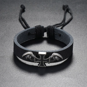 Close-up of vintage braided leather bracelet with silver cross and wings detail