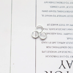 Detailed view of three white metal open jump rings for DIY jewelry craft making