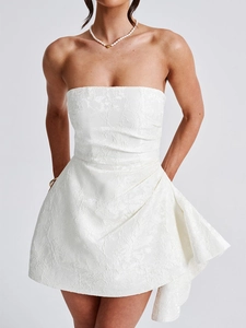 Detail shot of the white jacquard fabric texture on a strapless summer mini dress