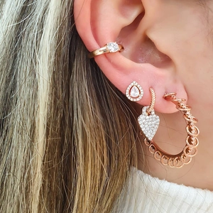 Close-up of rose gold bohemian earrings with a heart pendant and diamond zircon accents