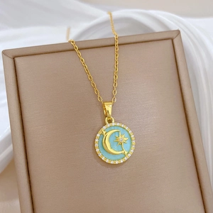 Detail of gold moon and star pendant with turquoise inlay and zircon borders