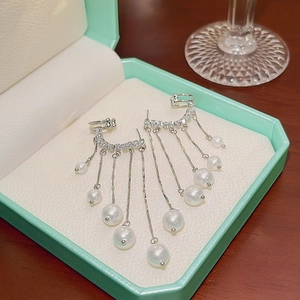 Detailed close-up of pearl tassel earrings with silver chains and sparkling zircons