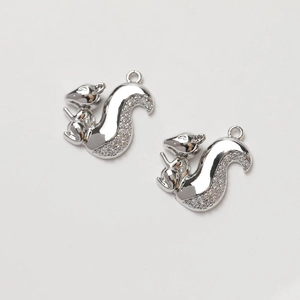 Detail view of two squirrel pendants with silver plating and sparkly rhinestones