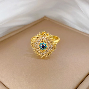 Macro detail of rotating evil eye starburst ring with gold plating and blue stones