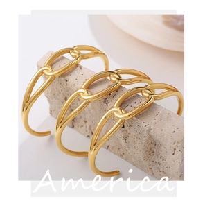 Detailed view of three 18K gold plated stainless steel chain link open bracelets on stone