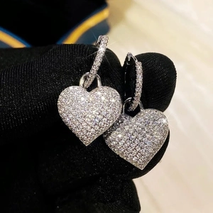 Makroaufnahme von Herzohrringen aus Silber mit Pavé-Kristallen auf Samt