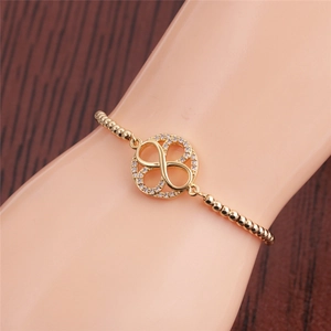 Detailed view of infinity symbol gold bracelet with cubic zirconia on a wrist model