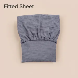 Detail of grey muslin cotton baby bassinet fitted sheet showing elasticated edges