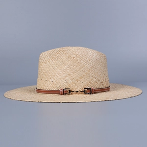 Detail of raffia straw sun hat with brown leather band and golden metal buckle