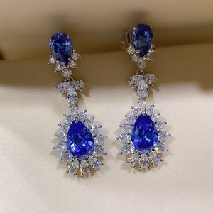 Close-up of luxury pear-cut blue gemstone earrings with sparkling crystal accents