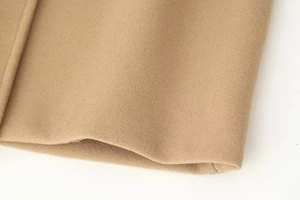 Close-up of camel wool coat sleeve showing high-quality fabric texture and fine stitching