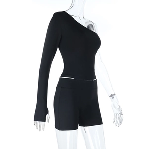 Detail of black two-piece set featuring one-shoulder long sleeve top and slim-fit shorts