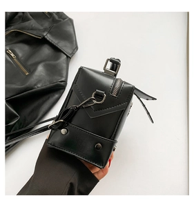 Detail of black leather punk crossbody bag with silver hardware and rivet accents