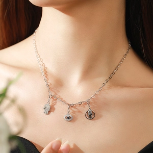 925 silver necklace with Hamsa hand and Evil Eye charms worn by a model