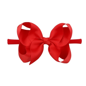 Detail of red ribbed nylon headband for babies featuring a full textured bow design