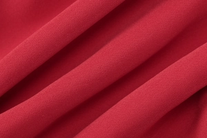 Detailed close-up of the red fabric texture and fine woven material of the dress