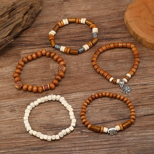 Detail of five-piece handmade wooden bead bracelets with elephant and butterfly charms