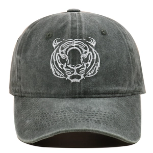 Close-up of intricate white tiger head embroidery on a vintage washed cotton baseball cap