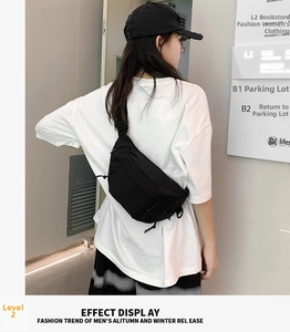 Detail of a black nylon crossbody bag featuring reinforced stitching and adjustable straps