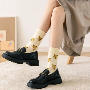 Cream yellow mid-calf socks with Shiba Inu cartoon print worn with black loafers