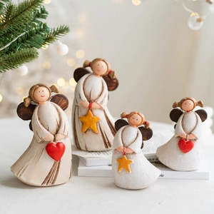 Set of four rustic resin angel figurines with hearts and stars for Christmas decor