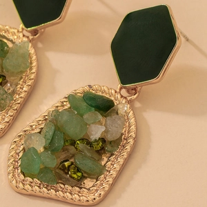 Close-up of geometric earrings with green stones and vintage gold woven textures
