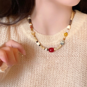 Vintage-Halskette mit Achat- und Kokosschalenperlen getragen auf einem Strickpullover