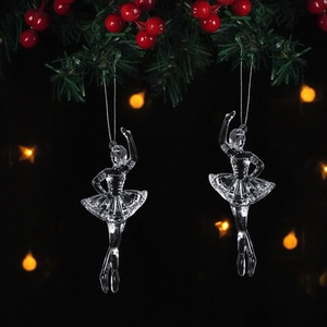 Detailed view of clear acrylic ballet dancer ornaments hanging on a Christmas tree branch