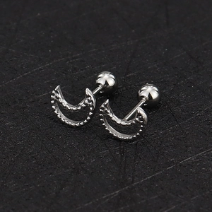 Macro shot of silver crescent moon cartilage studs with screw back ball closure detail
