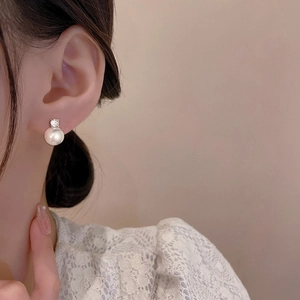 Elegant pearl and zircon stud earrings for women with silver finish shown on a model