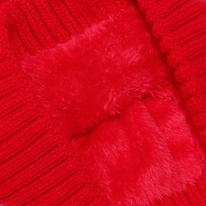 Macro shot of red knitted fabric texture and soft faux fox fur pompom detail