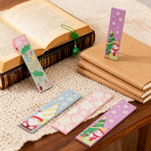 Detail van feestelijke DIY kerstbladwijzers met sneeuwman op een vintage boek