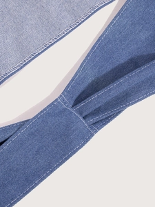 Macro detail of blue denim waist belt with white contrast stitching and soft pleated texture