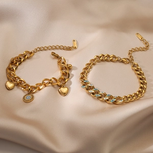 Gold plated stainless steel bracelets featuring evil eye and heart charms on satin