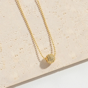 Macro view of gold beaded chain necklace with micro-paved round zircon sphere pendant