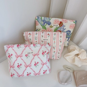 Détail de trois trousses à maquillage en coton fleuri avec étiquettes Simple Wish