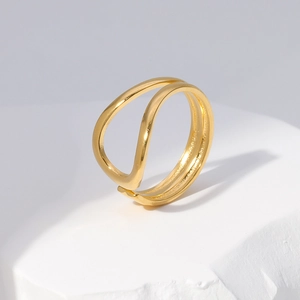 Macro shot of minimalist gold-plated wavy double-layer ring on white stone base