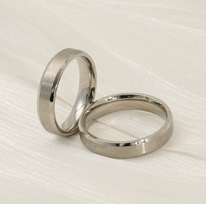 Close-up of titanium steel rings showing brushed and polished finishes on silk