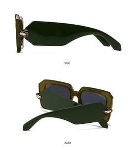 Detail of dark green oversized sunglasses with gold and black snake-shaped hardware