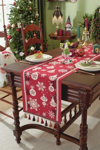 Close-up of red jacquard Christmas table runner with tassels and snowflake patterns