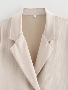 Gros plan du blazer beige à double boutonnage avec texture plissée verticale et étiquette S
