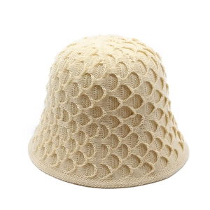 Detailed macro view of the cream knitted bucket hat featuring a scallop wave texture