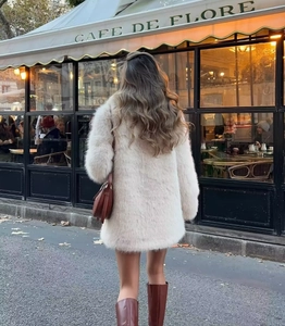 Manteau en fausse fourrure blanc crème présenté dans un style urbain chic parisien