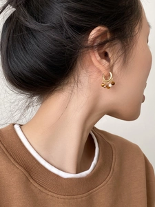 Détail de boucles d'oreilles vintage plaquées or 18k avec œil de tigre et perles sur mannequin