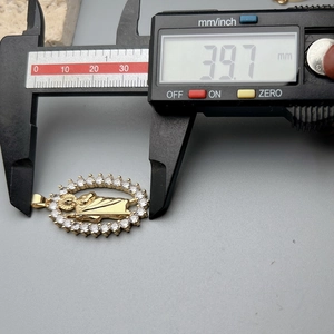 Detailed view of golden Jesus heart pendant being measured with a digital caliper, size 39.7mm