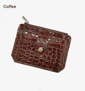 Macro shot of coffee brown crocodile pattern leather wallet with snap and zipper detail