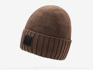 Close-up of thick ribbed knit texture and mountain logo leather patch on winter beanie