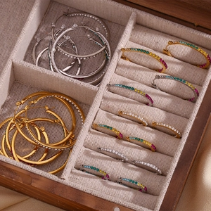 Detailed top view of gold and silver hoop earrings with rhinestones in a jewelry box