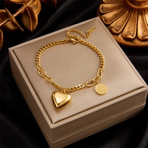 Gold multi-layer chain bracelet with engraved heart and circle pendants on black silk